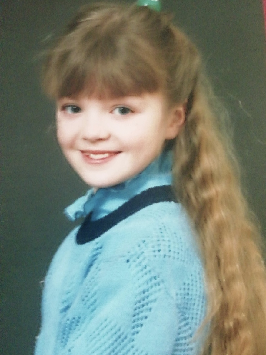 Childhood portrait of Eline Mets wearing a blue sweater